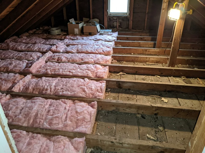 Attic with fresh insulation batts between joists